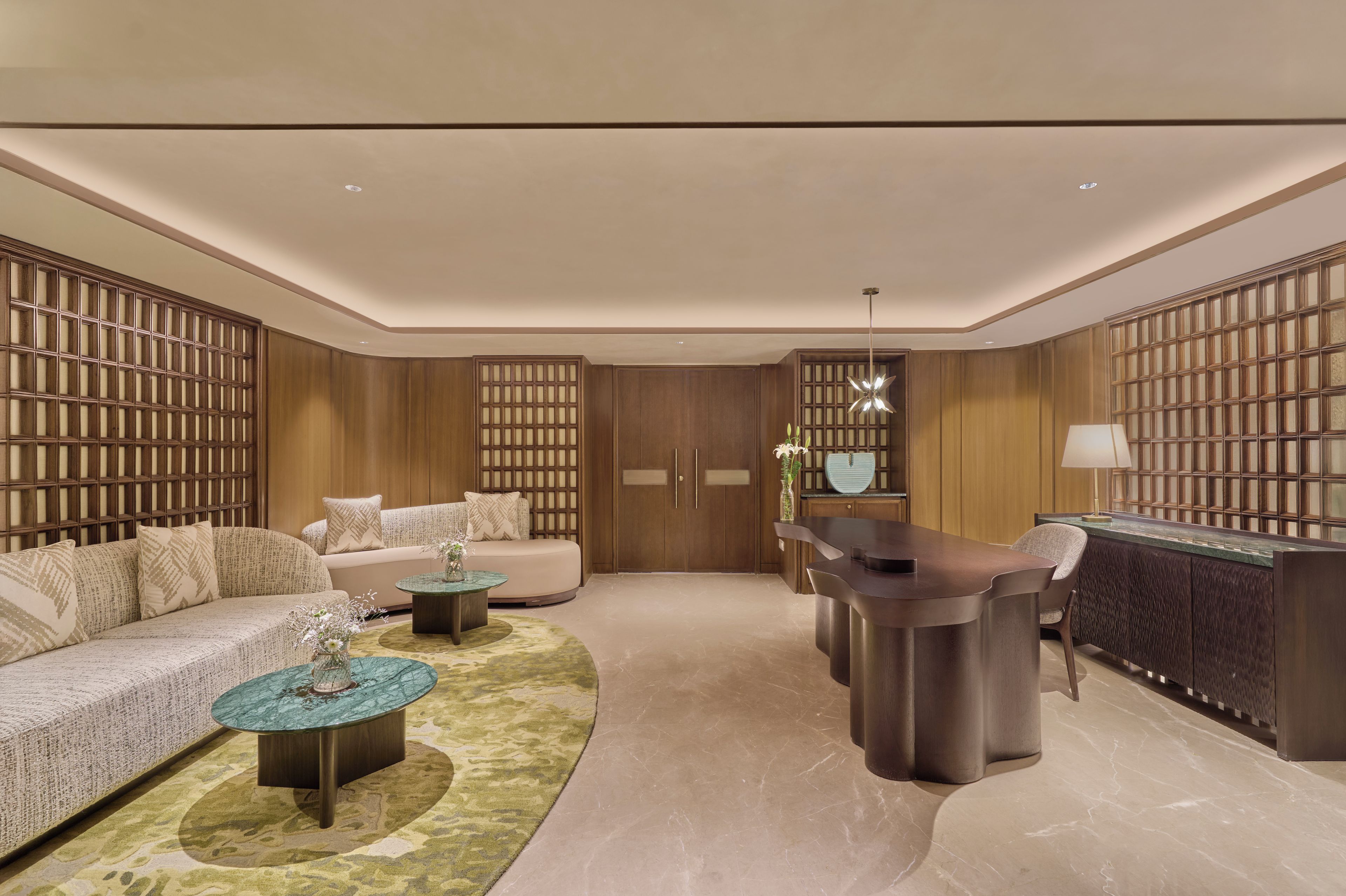A modern living room with a sofa, coffee table, and a dining area with a bar.