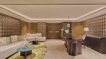 A modern living room with a sofa, coffee table, and a dining area with a bar.