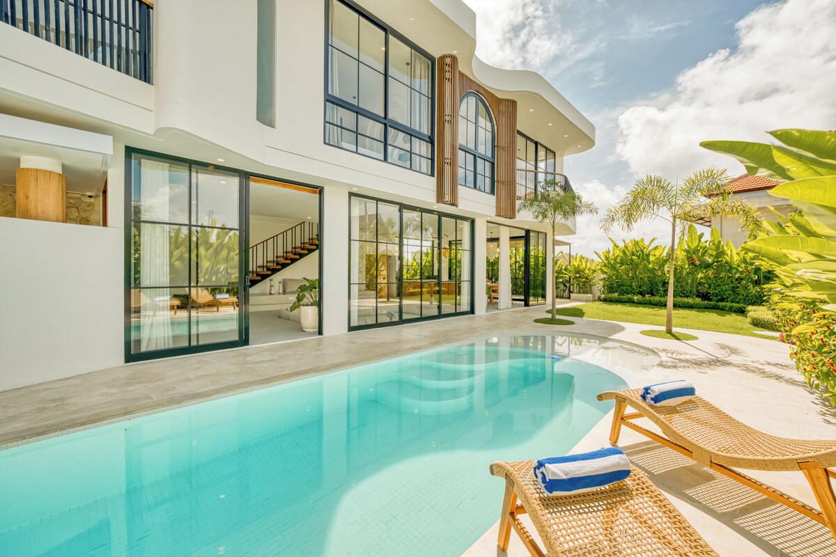 A modern house with a swimming pool, outdoor seating, and a well-maintained garden.