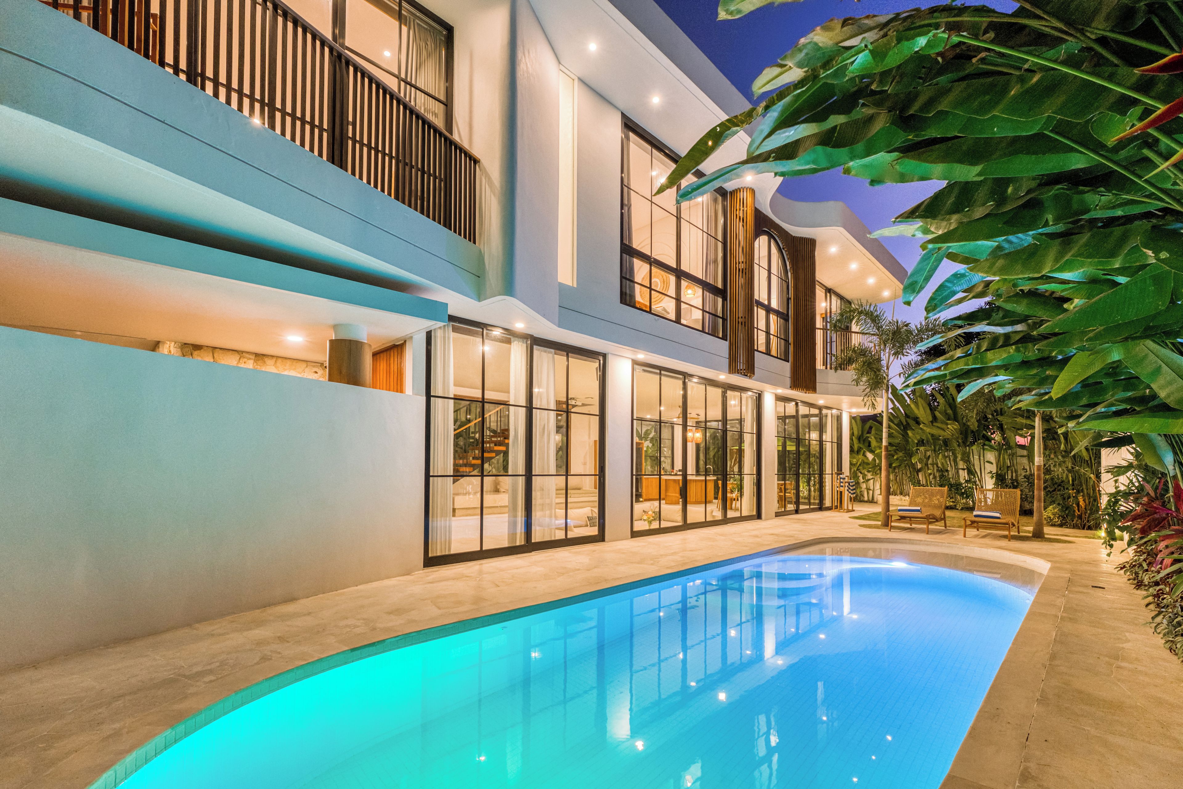 Un edificio moderno con piscina, ventanas amplias y balcón.