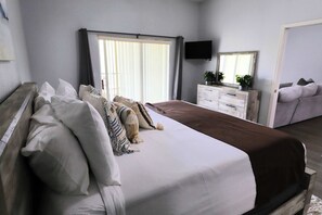 A bedroom with a large bed, a dresser, a television, and a sofa. - Penthouse in Bahama Bay Resort near Disney w/4 pools, 6 spas, tennis courts, A/C (Davenport)