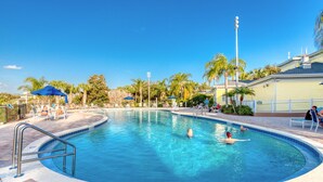 Ein Swimmingpool mit einer Tiefenmarkierung von 6 Fuß, umgeben von Palmen und Liegestühlen.