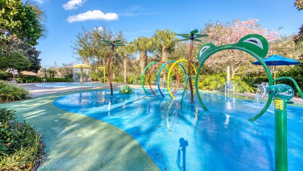 A water play area with colorful structures and a clear blue sky. - 2nd floor condo near theme parks, balcony, pools, restaurant, basketball court (Davenport)