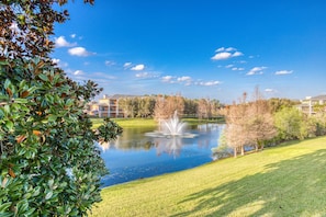 A serene park with a pond, a fountain, and a well-maintained lawn. - 2nd floor condo w/ restaurant, sauna, shared pools, gym, balcony (Davenport)
