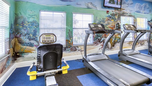 A gym with treadmills, a stationary bike, and a rowing machine. - Exclusive 3BR Villa: Pools, Near Disney (Davenport)