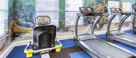 Ein Fitnessraum mit Laufbändern, Fahrrädern und Rudergeräten.