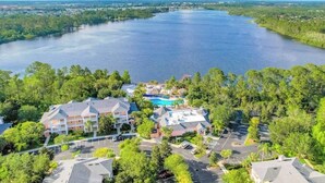 A resort with multiple buildings, a swimming pool, and a large body of water. - 1st floor condo w/ basketball court, gym, sauna, shared pools, near theme parks (Davenport)