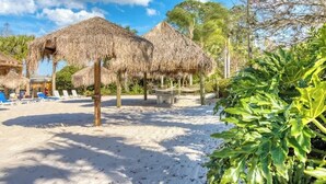 A beach with thatched umbrellas, lounge chairs, and a sandy area. - 1st floor condo w/ basketball court, gym, sauna, shared pools, near theme parks (Davenport)