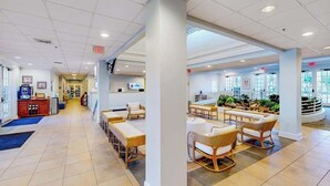 A hotel lobby with a reception desk, seating area with wicker chairs, and a view of the outdoors. - 1st floor condo w/ basketball court, gym, sauna, shared pools, near theme parks (Davenport)