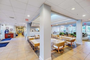 A hotel lobby with a reception desk, seating area with wicker chairs, and a view of the outdoors. - 1st floor condo w/ basketball court, gym, sauna, shared pools, near theme parks (Davenport)