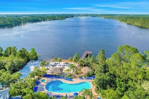 Un complexe hôtelier doté d’une grande piscine, de chaises longues et offrant une vue sur une vaste étendue d’eau.