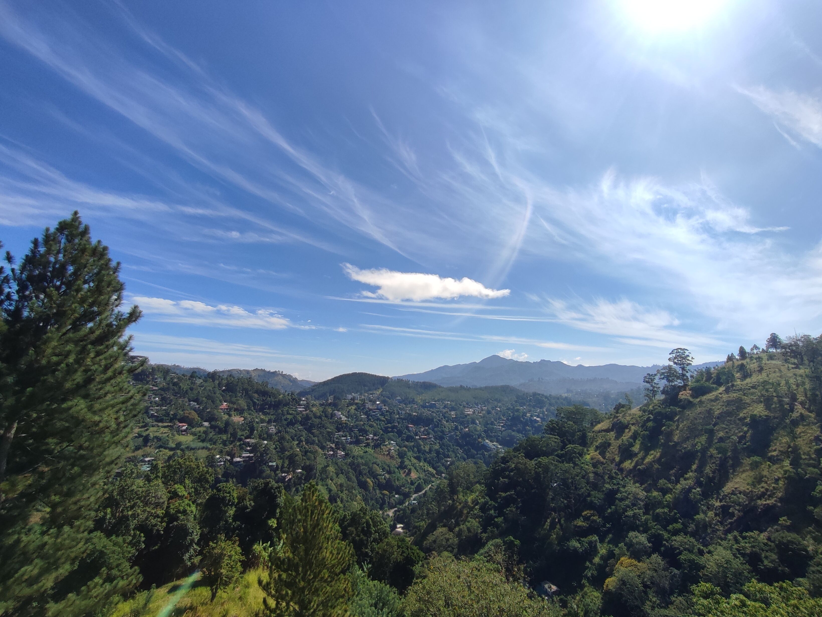 A panoramic view of a mountainous landscape with a village nestled among the hills.