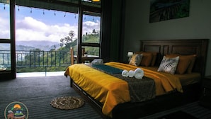 A bedroom with a large bed, a view of the mountains, and a balcony. - Ella T & D Resort (Ella)