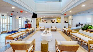 A spacious lobby with wicker furniture, a central round table, and a reception desk. - First floor lake view condo w/ pool & hot tub access, private W/D, & central AC (Davenport)