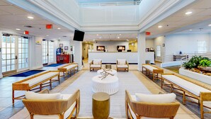 A spacious lobby with a high ceiling, multiple seating areas, and a reception desk. - Snowbird-Friendly, First Floor Condo w/ Shared Pool & Hot Tub, and Central AC (Davenport)
