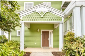 A green house with a brown door, white trim, and a decorative roof. - 1st floor condo near theme parks, sauna, tennis court, basketball court, patio (Davenport)