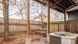 An outdoor patio area with a wooden fence, a bench, and an air conditioning unit. - Historic German Village Cottage - Perfect Downtown Location - Highly Walkable! (Columbus)