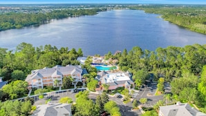 Ein Hotel mit Schwimmbad, umgeben von üppigem Grün und einem großen See.