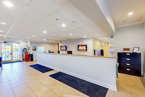 A reception area with a counter, a clock, and a computer monitor. - First floor condo w/ sauna, pools, restaurant, tennis court (Davenport)