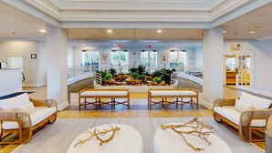 A spacious lobby with a central water feature, seating areas, and a view of the outdoor area. - Second floor condo w/ balcony, basketball court, gym, tennis court, sauna (Davenport)