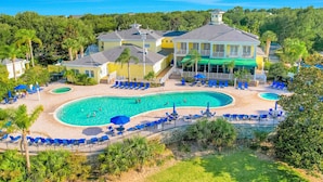 A resort with a large pool, multiple lounge areas, and a prominent building with a balcony. - 2nd floor condo w/ gym, shared pools, tennis court, balcony, sauna (Davenport)