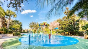 A water play area with a circular pool, surrounded by palm trees and greenery. - 2nd floor condo w/ gym, shared pools, tennis court, balcony, sauna (Davenport)