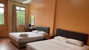 Une chambre d’hôtel avec deux lits, un bureau, une chaise et une fenêtre avec des rideaux.
