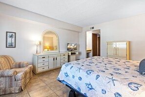 A bedroom with a bed, a dresser, a chair, and a television. - Cocoa Beach Escape Condo W/ Private Balcony, Heated Pool, Hot Tub, and Tennis Courts! 🏖️☀️ (Cocoa Beach)