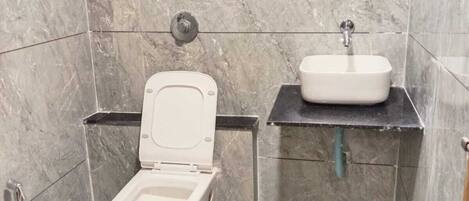 Un baño con inodoro, lavabo y espejo.