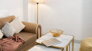 Un soggiorno moderno con un divano, un tavolino, una lampada e un quadro appeso al muro.