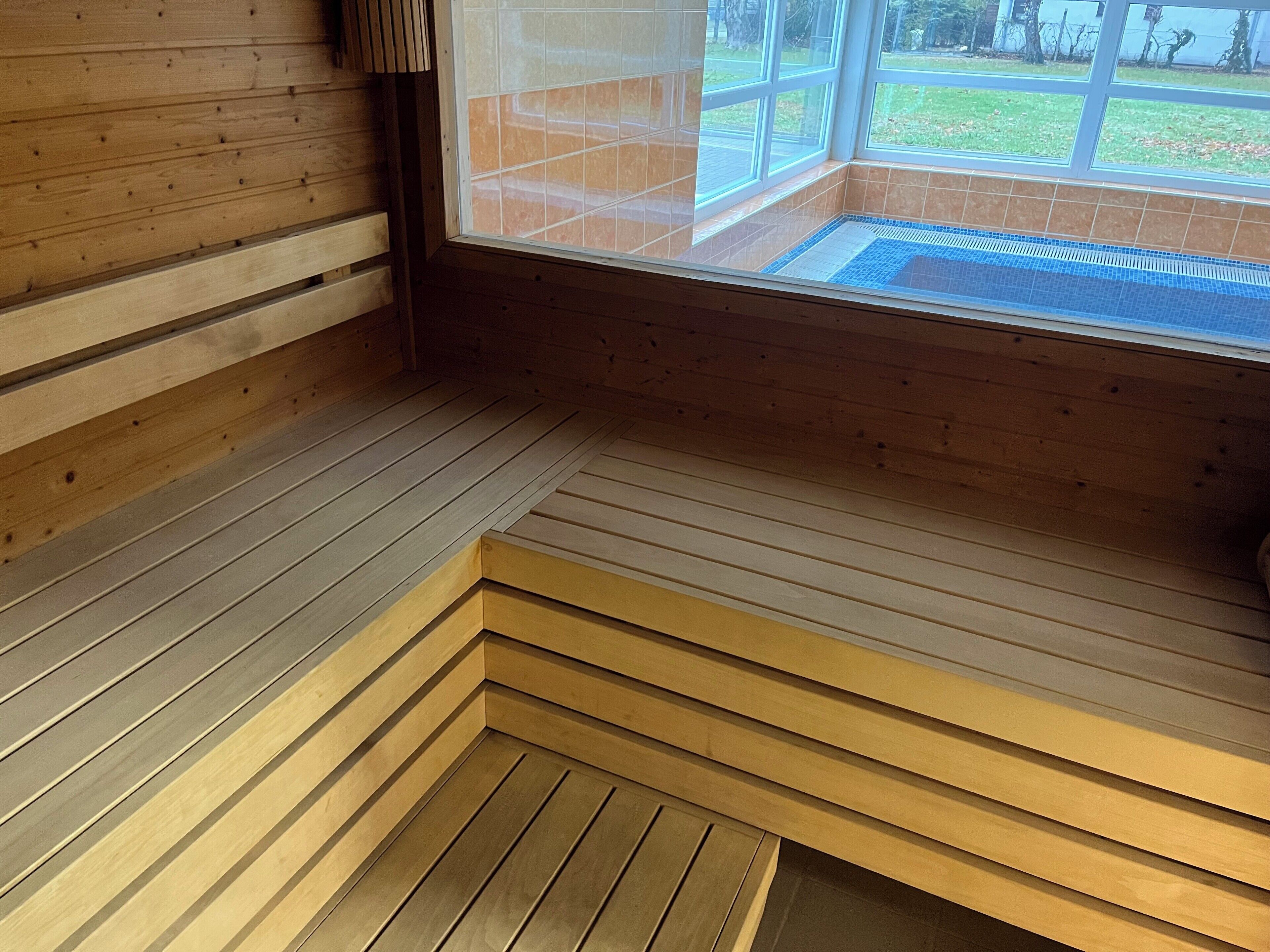 Una sauna de madera con un banco y una ventana.