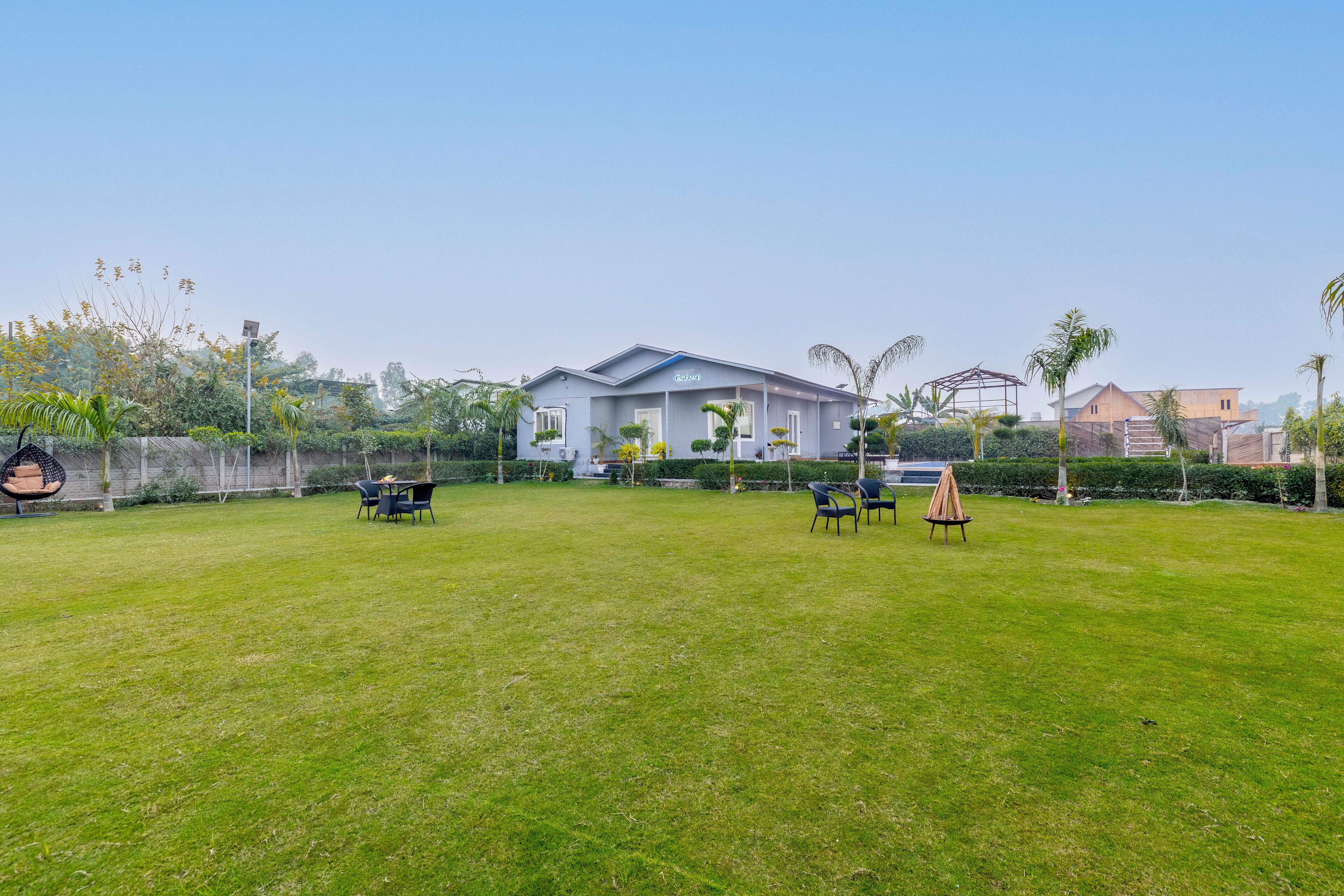A house with a spacious lawn, outdoor seating, and a well-maintained garden.