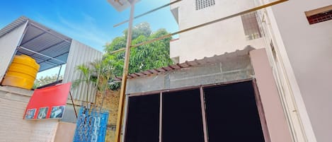 A building with a large window, a yellow water tank, and a blue gate.