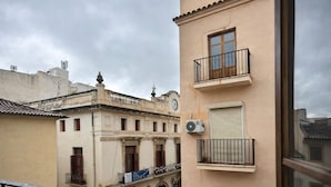 Ein Gebäude mit Balkon, einer Uhr und einer Klimaanlage.