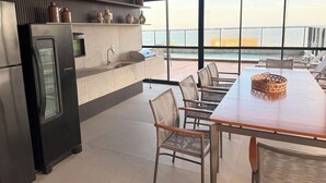 Una cocina moderna con refrigerador, pileta y comedor con mesa y sillas.