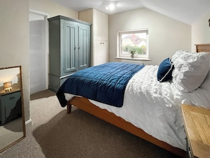 A bedroom with a bed, a wardrobe, a window with a view, and a mirror. - 3 bedroom accommodation in Chapel St. Leonards (Chapel St. Leonards)