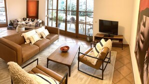 Un salon avec un canapé marron, une table basse et un meuble pour la télévision.