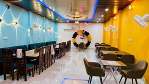 Un restaurante con un amplio comedor, múltiples mesas y sillas.