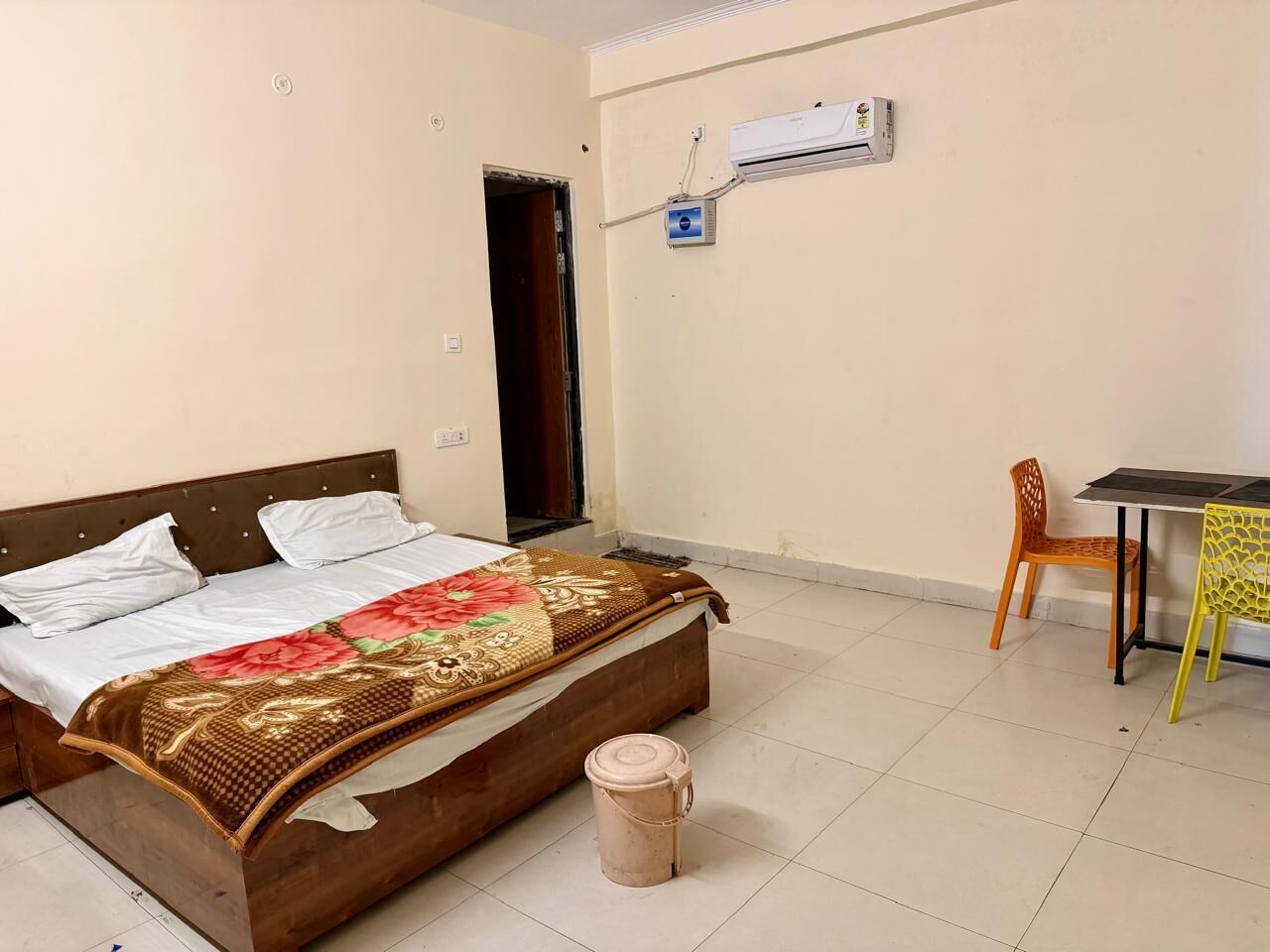 A bedroom with a bed, a small table, and a chair.