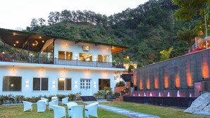 A two-story building with a covered outdoor seating area and a landscaped garden.