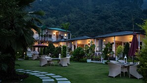 A resort with a well-maintained lawn, outdoor seating, and a stone pathway leading to the buildings.