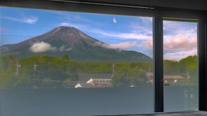Une pièce dotée d’une grande fenêtre donnant sur une montagne et un plan d’eau.