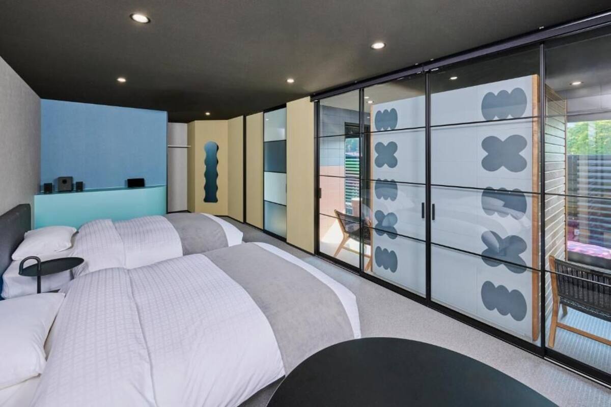 Un dormitorio moderno con una cama grande, un escritorio y un armario con diseños de mariposas.
