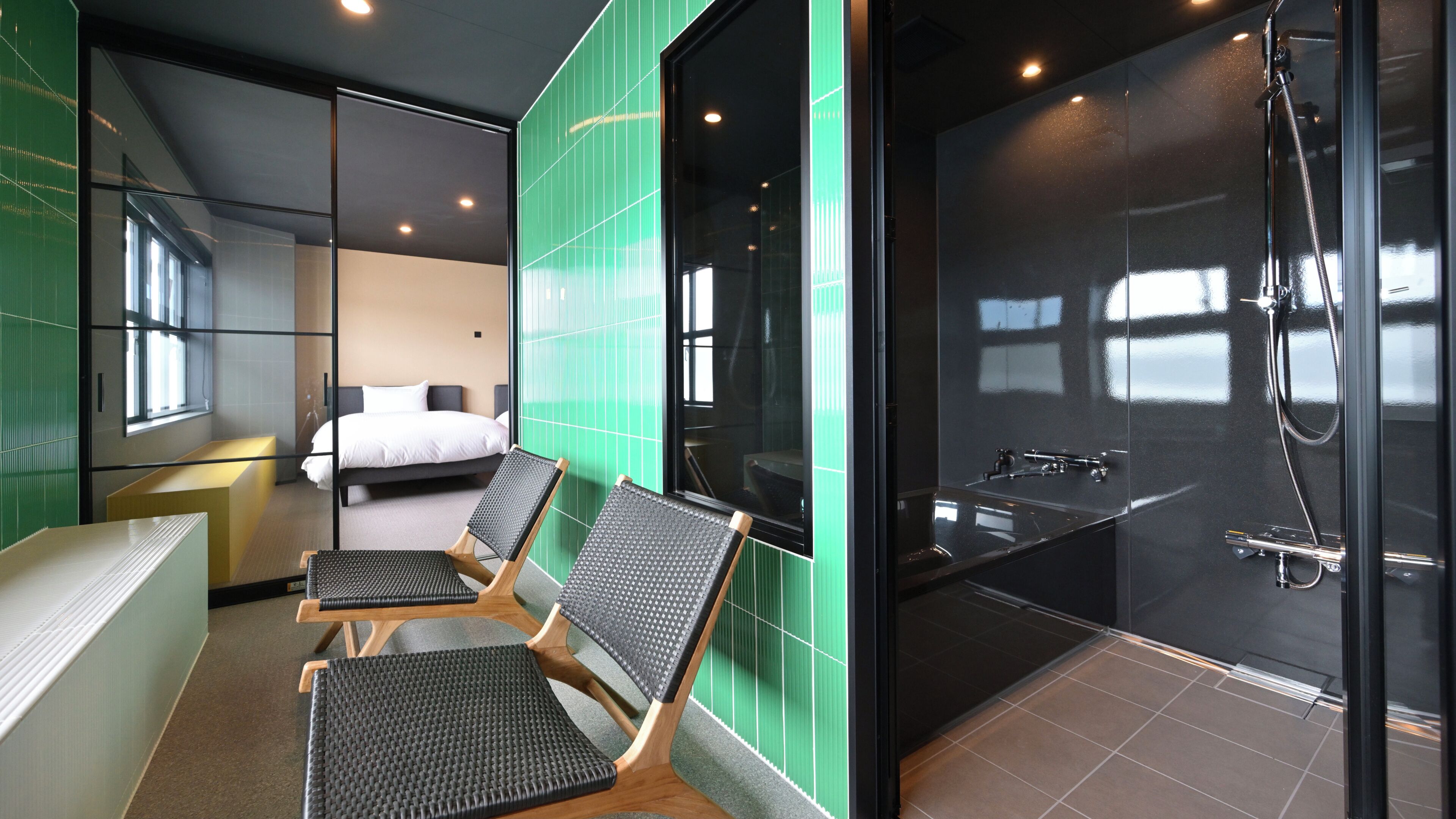 Une chambre d’hôtel avec un lit, deux chaises, une douche et une vue sur l’extérieur.