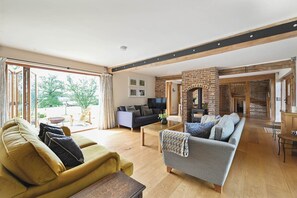 A spacious living area with a sofa, a coffee table, and a fireplace. - Hare Farm Oast - amazing views - ideal for family celebrations (Rye)