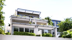 Ett modernt hus i två våningar med ett platt tak, stora fönster och ett garage med tak.