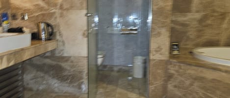 Un bagno moderno con cabina doccia in vetro, vasca da bagno e mobile lavabo.