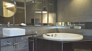 Une salle de bain moderne avec une grande baignoire, un lavabo et un miroir.