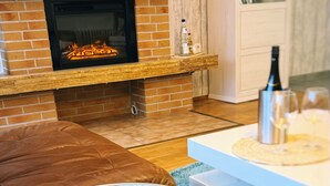Un salon avec une cheminée, un téléviseur, un canapé et une table basse.