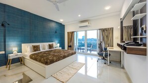 Un dormitorio moderno con una cama grande, un escritorio y un balcón con vistas.